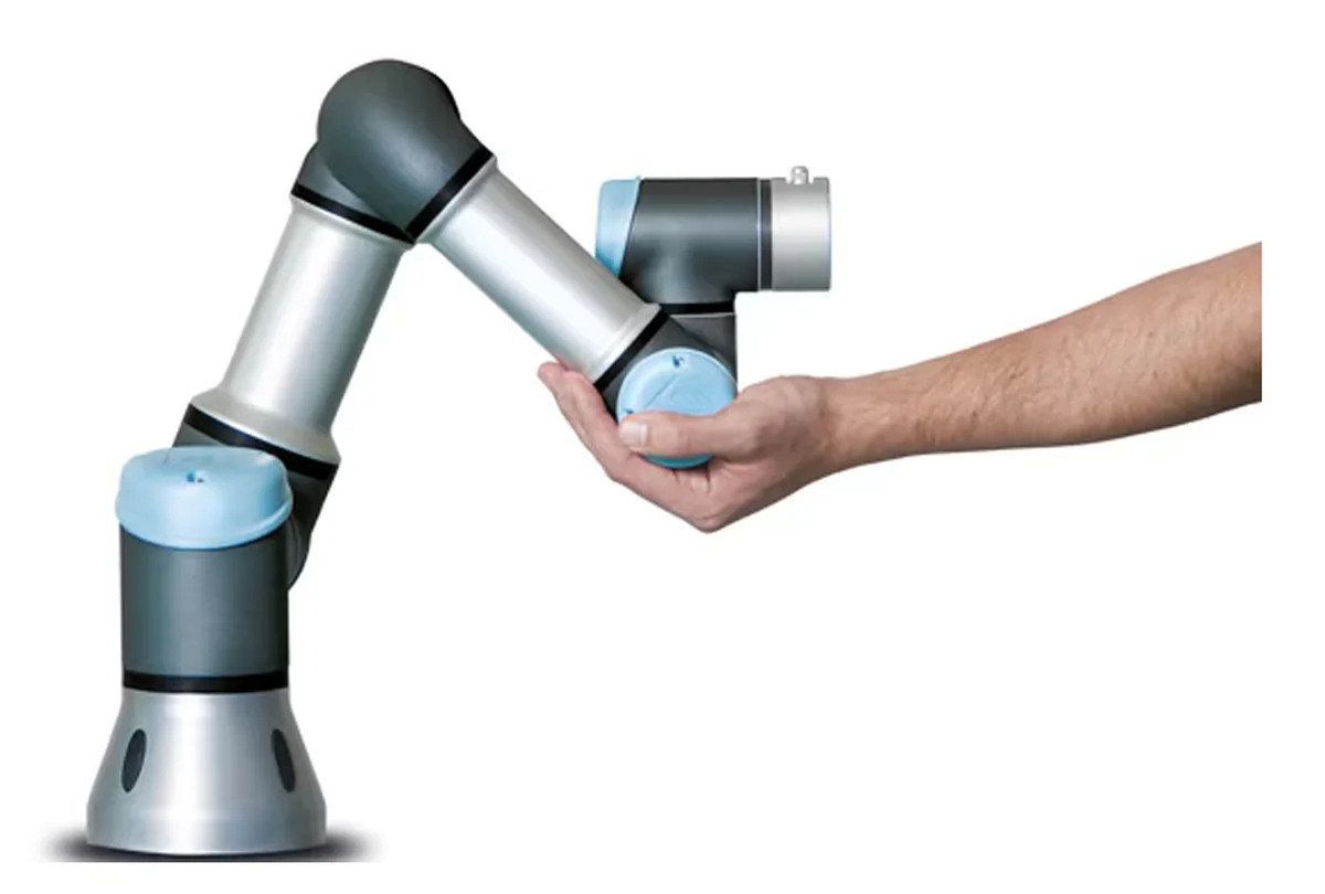 A Universal Robots UR-10e arm being guided by a human hand
