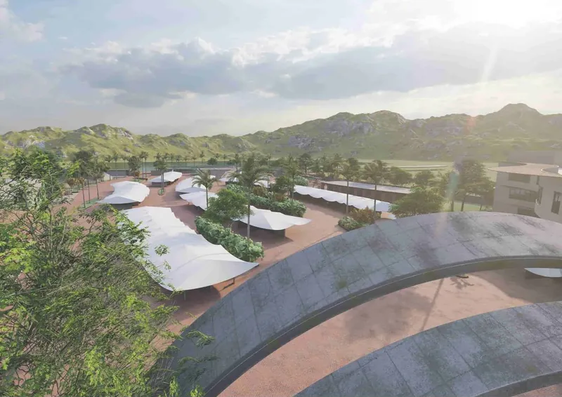Drone view of the bazaar: rows of white tensile canopies over a paved plaza beside a curved stone wall and trees